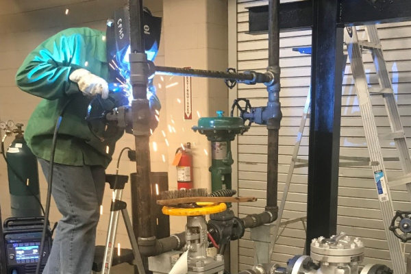 A student works on a barbecue skid as part of the 2021 industrial craft competition